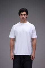 Man wearing a plain crew neck white t-shirt in regular fit against a gray background