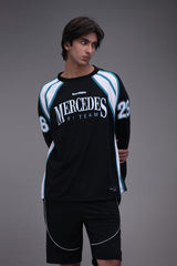 Person wearing a Mercedes F1 Team racing suit on a gray background