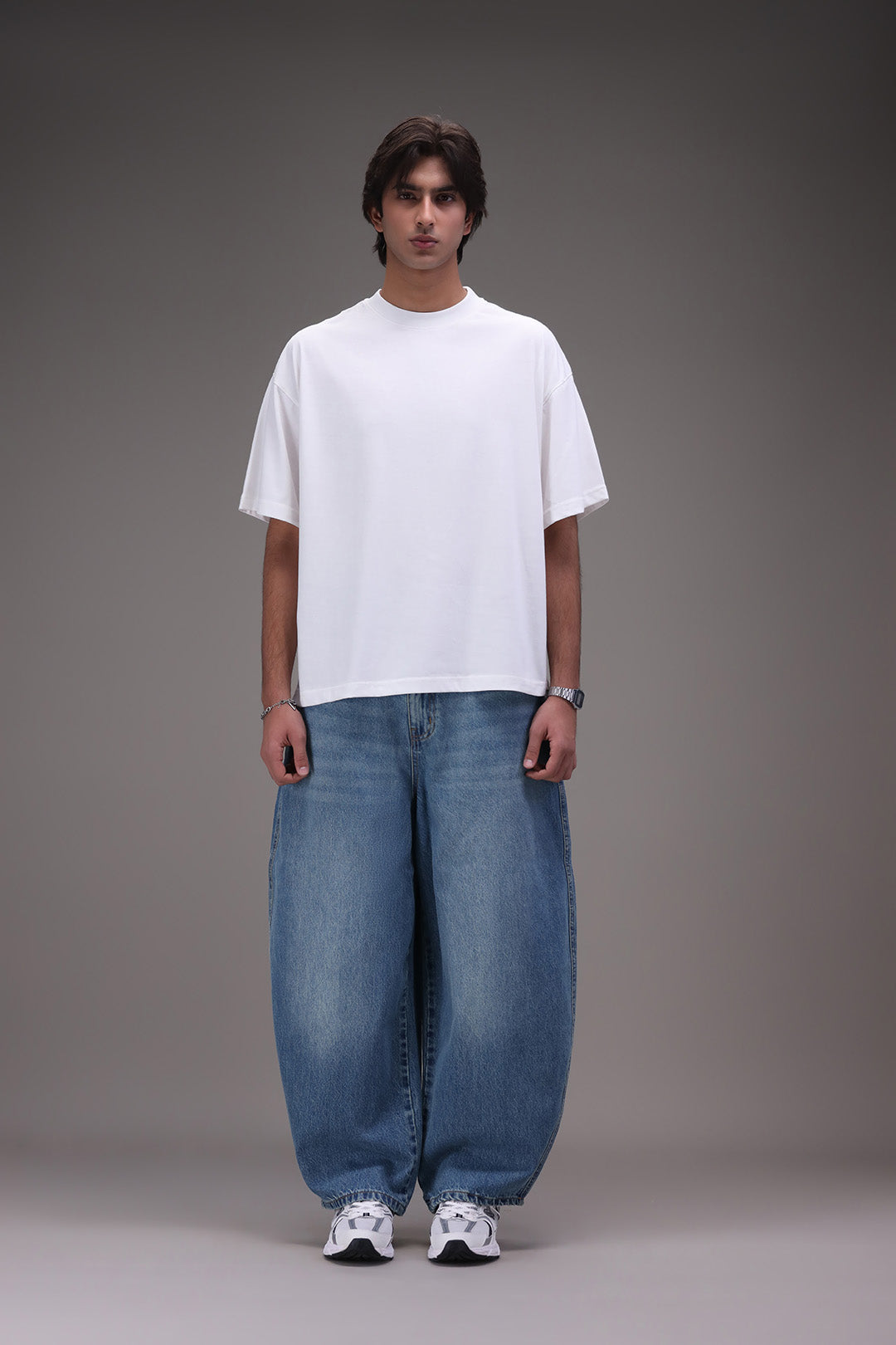 Person wearing Daigen's white boxy t-shirt and blue barrel jeans with new balance sneakers. 