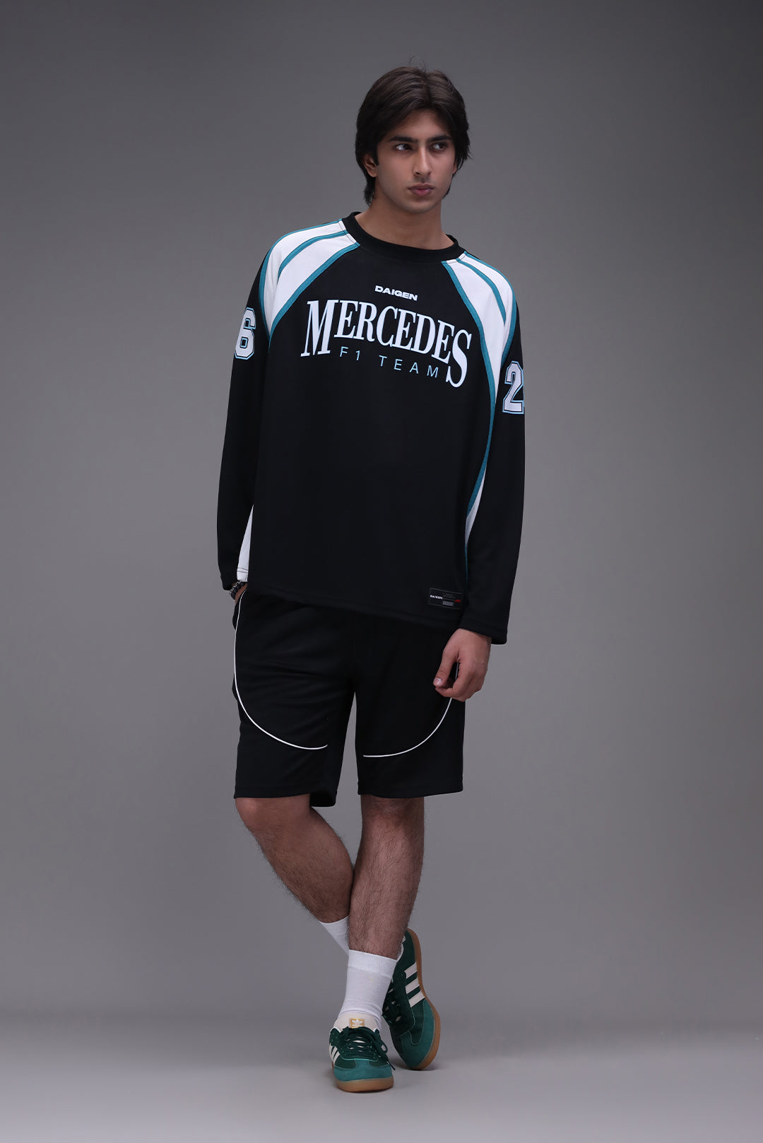 Person wearing a black Mercedes F1 team jersey and mercedes piping shorts on a gray background