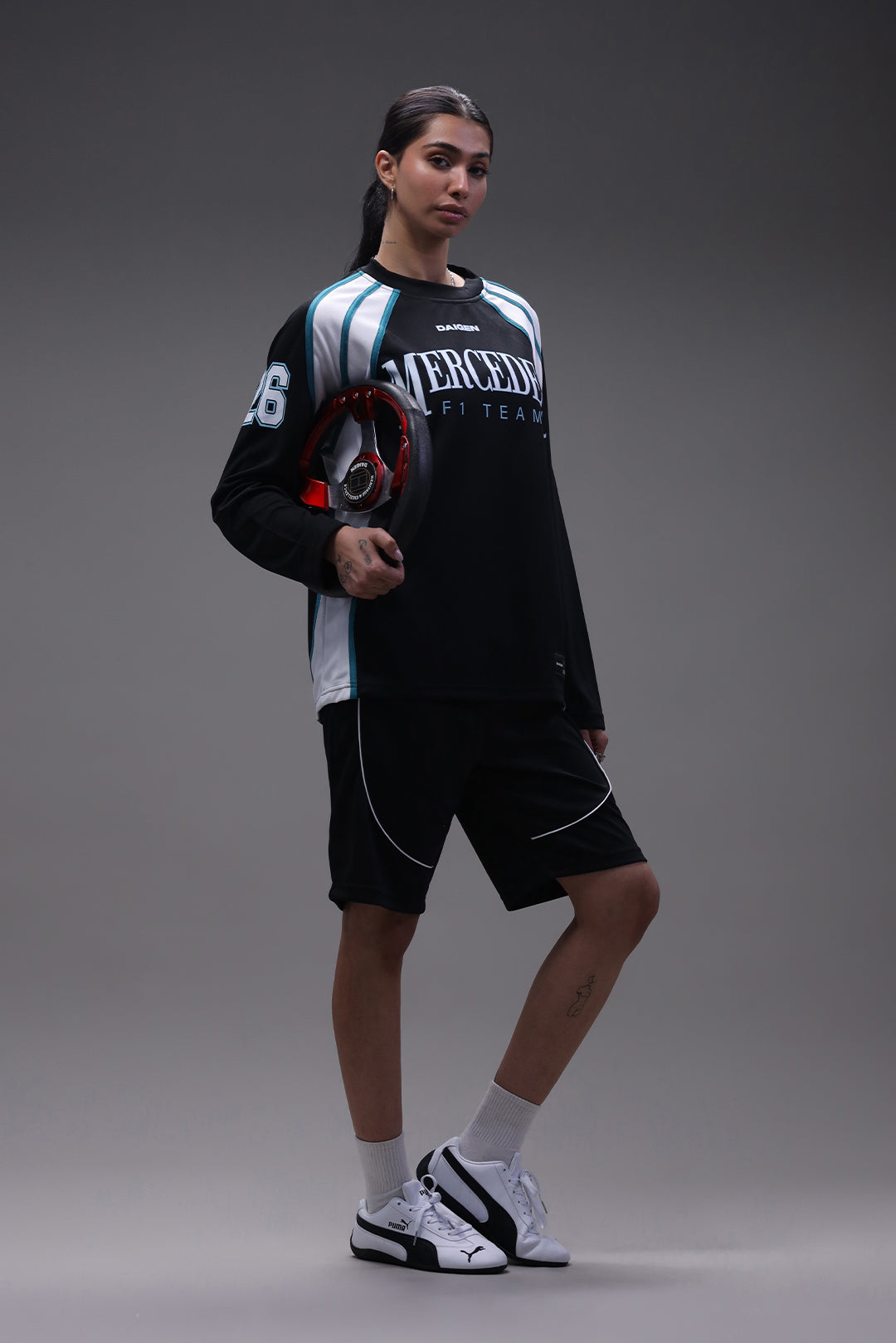 Person wearing a black and white sports outfit with visible branding on a gray background