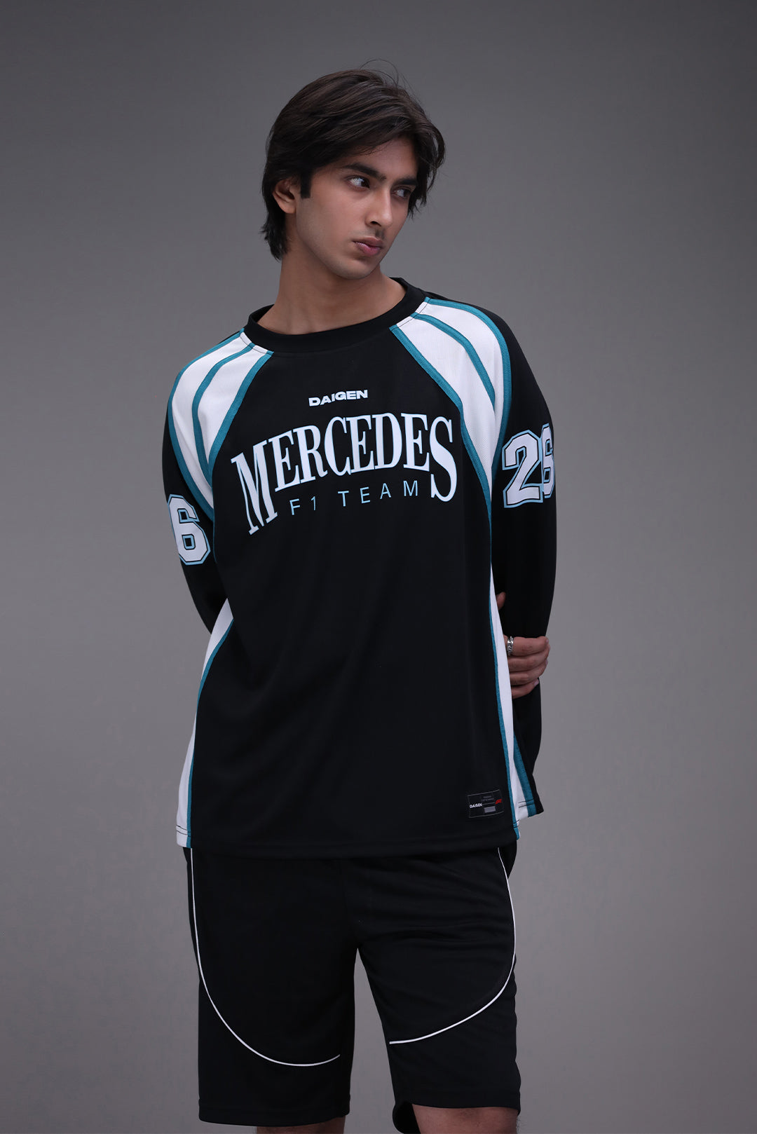 Person wearing a Mercedes F1 Team racing suit on a gray background