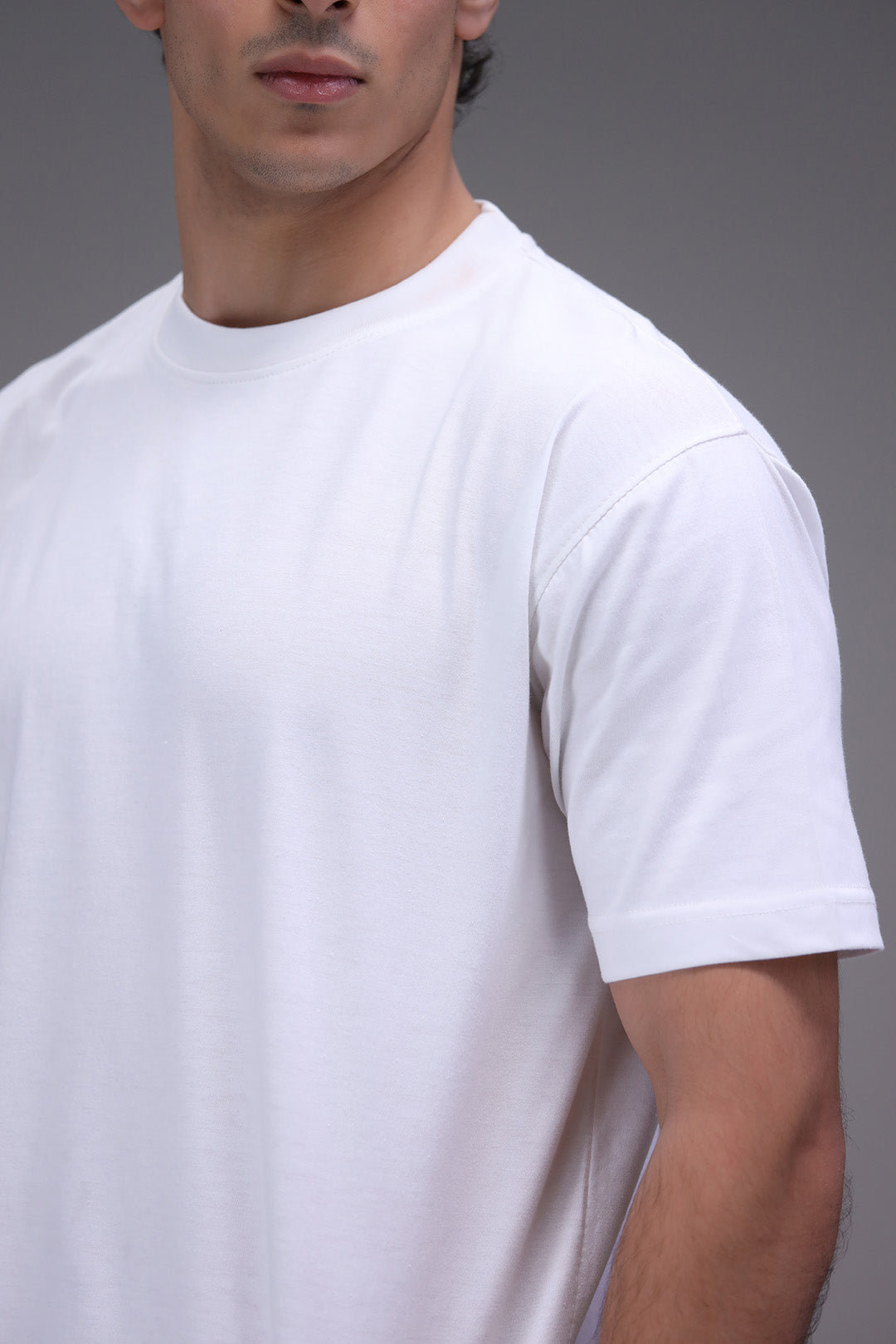 Man wearing a plain white t-shirt showing closeup fabric fit and detailing
